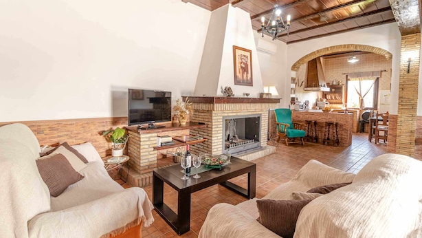 A cozy living room with a fireplace, comfortable seating, and a television.