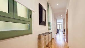 A hallway with a radiator, a mirror, and a window with green shutters. - INNER CITY CENTER ON PASEO DE GRACIA, luxurious & spacious, family & friends    (Barcelona)
