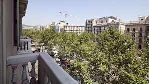 A balcony with a view of a cityscape, including buildings and a construction crane. - INNER CITY CENTER ON PASEO DE GRACIA, luxurious & spacious, family & friends    (Barcelona)