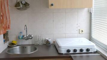 Een koelkast, een magnetron, kookgerei, borden en bestek