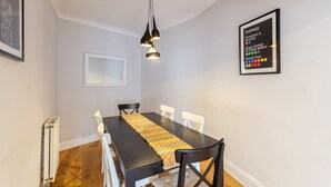 A dining area with a table, chairs, a pendant light, and a subway map on the wall. - Beautifully Modernised New Town Home for 5 (Edinburgh)