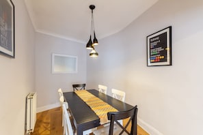 A dining area with a table, chairs, a pendant light, and a subway map on the wall. - Beautifully Modernised New Town Home for 5 (Edinburgh)