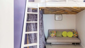A bunk bed with a ladder, a sofa with colorful cushions, and a framed picture on the wall. - Beautifully Modernised New Town Home for 5 (Edinburgh)