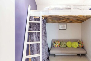 A bunk bed with a ladder, a sofa with colorful cushions, and a framed picture on the wall. - Beautifully Modernised New Town Home for 5 (Edinburgh)