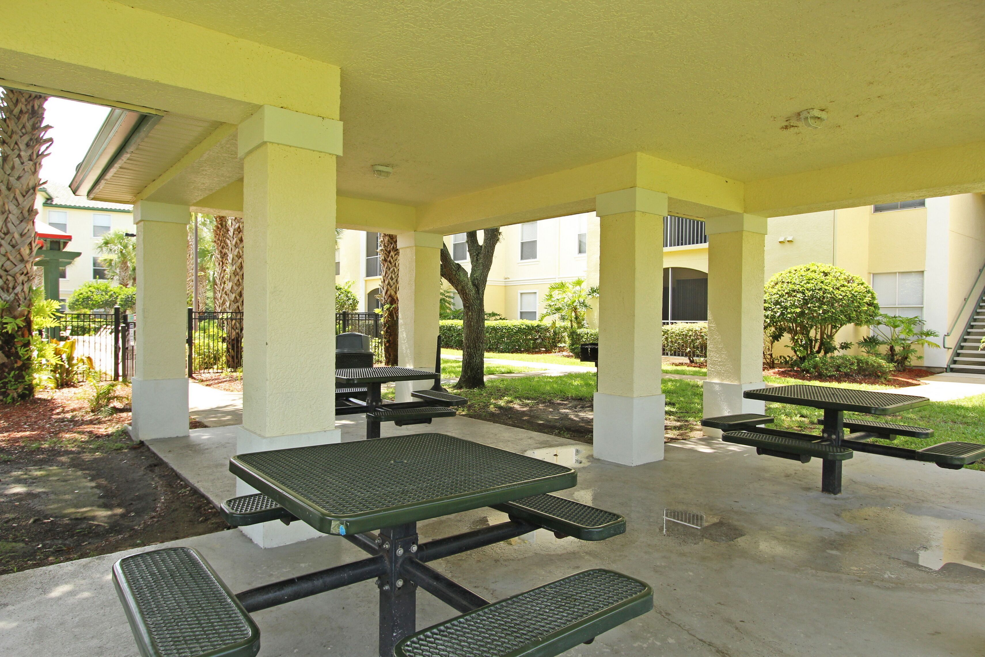An outdoor patio area with picnic tables and a covered seating area.