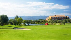 A golf course with a clubhouse, a pond, and mountains in the background. - ALMADRAVASOL·COM - Fantastic terraced house with parking, wifi and climatisation (Roses)
