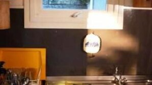 A kitchen with a window, a sink, and cabinets.