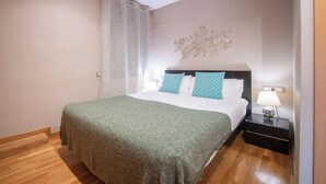 Una camera da letto ordinata con un letto, un comodino, una lampada e un elemento decorativo a parete.