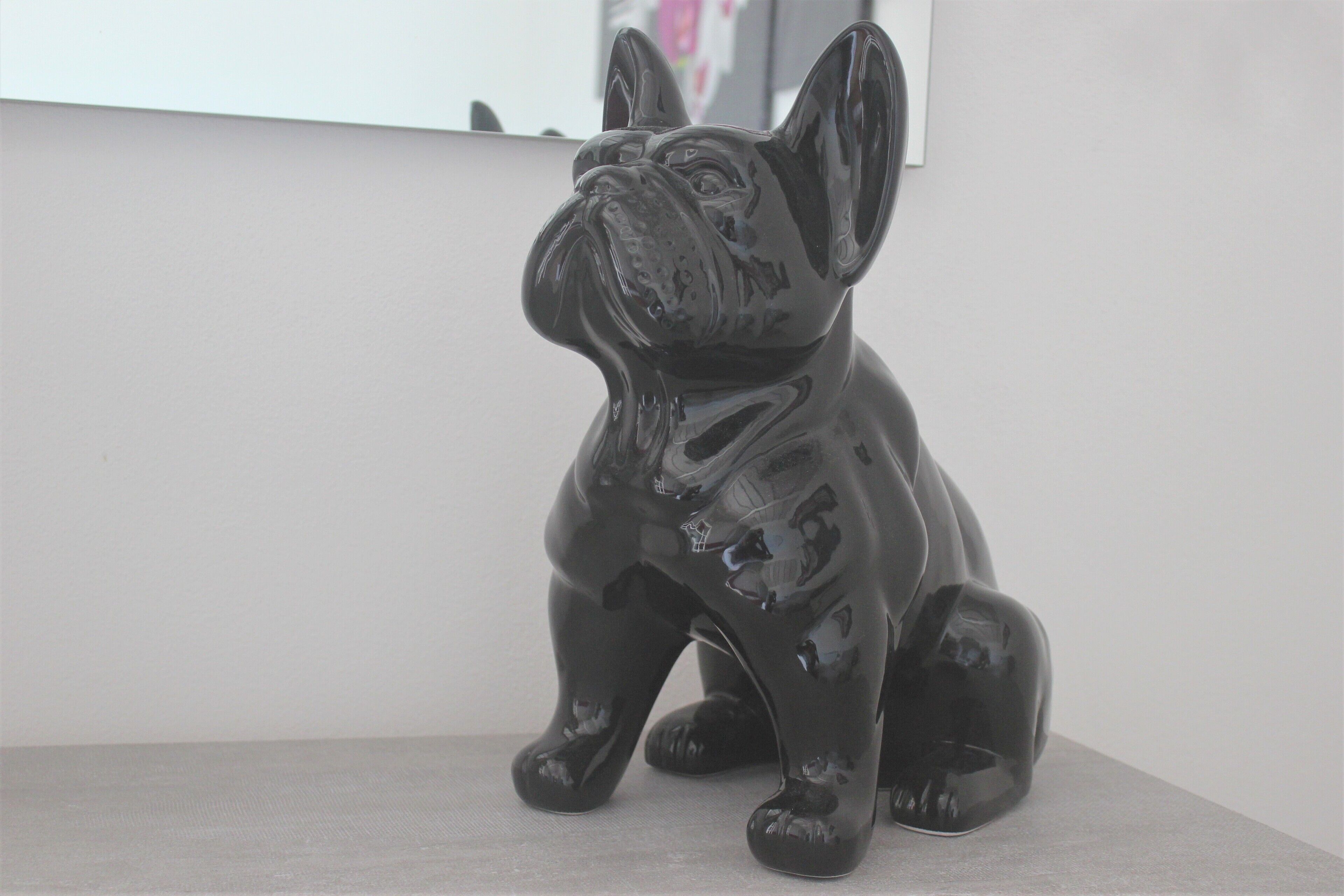 Una figurina di un cane nero lucido su una superficie piana.