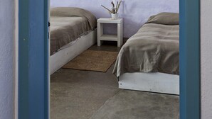 A bedroom with two beds, a nightstand, and a wall mural.