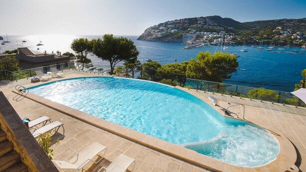 A swimming pool with a view of the sea and boats, surrounded by trees and a hillside with buildings. - VILLA WITH SEA VIEWS, DIRECT ACCESS TO SEA, SWIMMING POOL AND PERFECT LOCATION (Port D'Andratx)