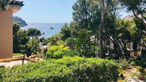 A coastal view with a building overlooking the sea, surrounded by trees and greenery. - VILLA WITH SEA VIEWS, DIRECT ACCESS TO SEA, SWIMMING POOL AND PERFECT LOCATION (Port D'Andratx)