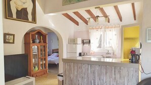 A compact living space with a kitchen area, a dining table, and a TV in the living room. - villa CELINE  - Moraira (Moraira)
