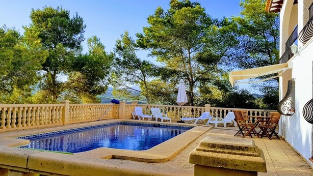 A pool area with a clear view of the surrounding trees and a building with a balcony. - villa CELINE  - Moraira (Moraira)