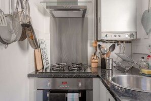 Eine moderne Küche mit Edelstahlgeräten, einem Gasherd, einem Backofen und einer Spüle.