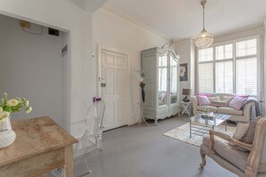 Una sala de estar con un sofá, una mesa de centro y adornos decorativos.