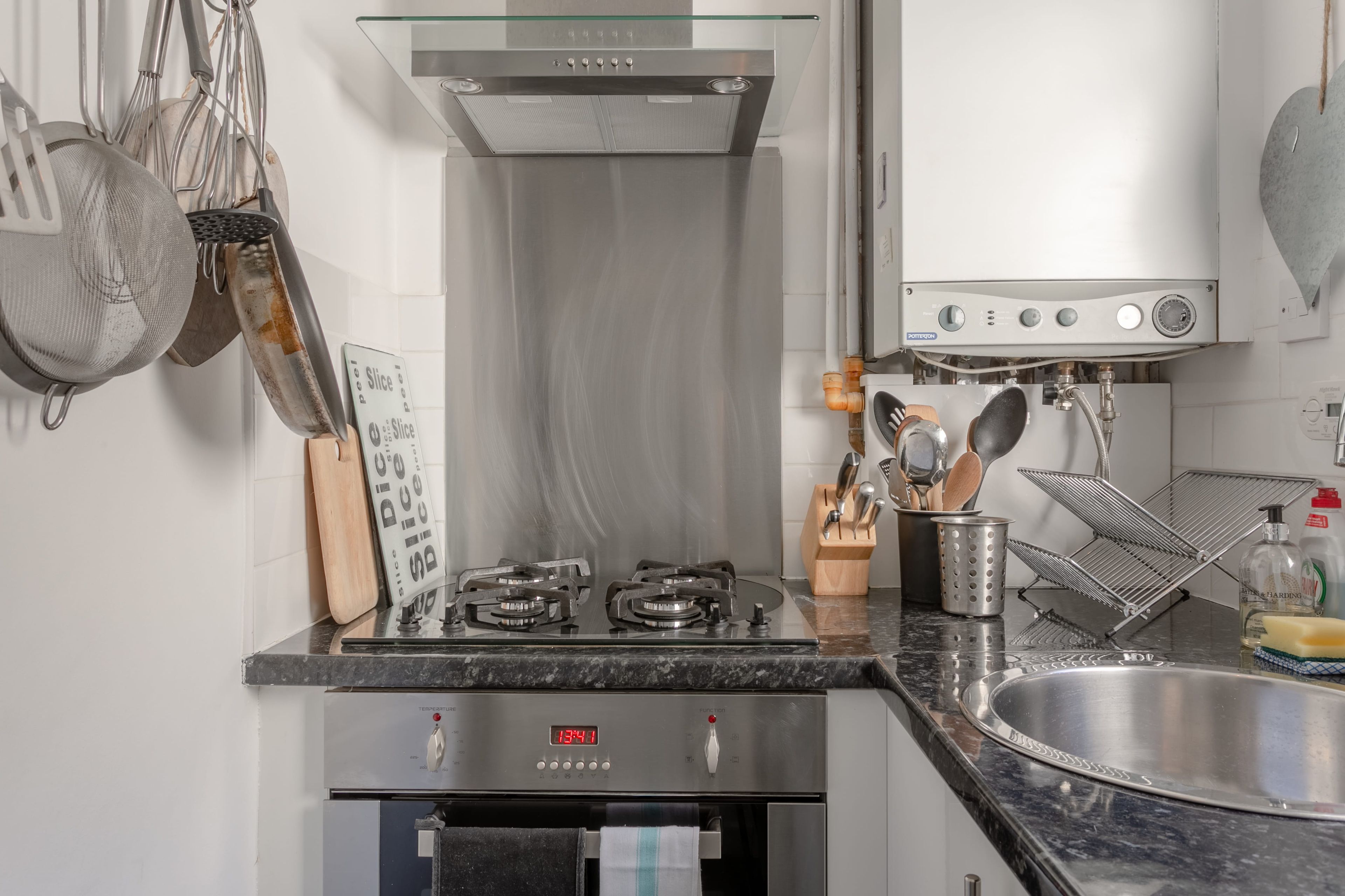 A modern kitchen with a stainless steel range, a built-in oven, and a sink.