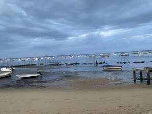 Uma praia com barcos ancorados na água e uma faixa de areia.