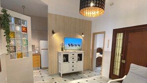 Un saló amb televisió, un sofà, una taula de centre i un paviment amb dibuixos.