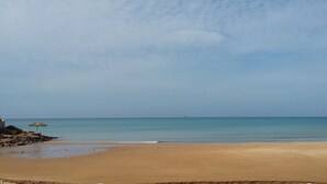 Una playa con arena y agua tranquila.