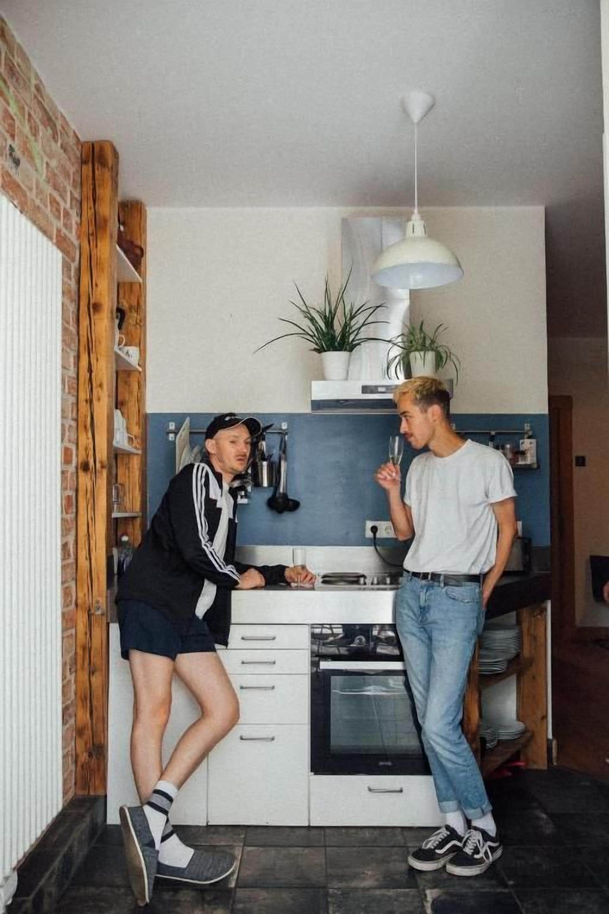 A kitchen with white cabinets, a black countertop, and a hanging light fixture.