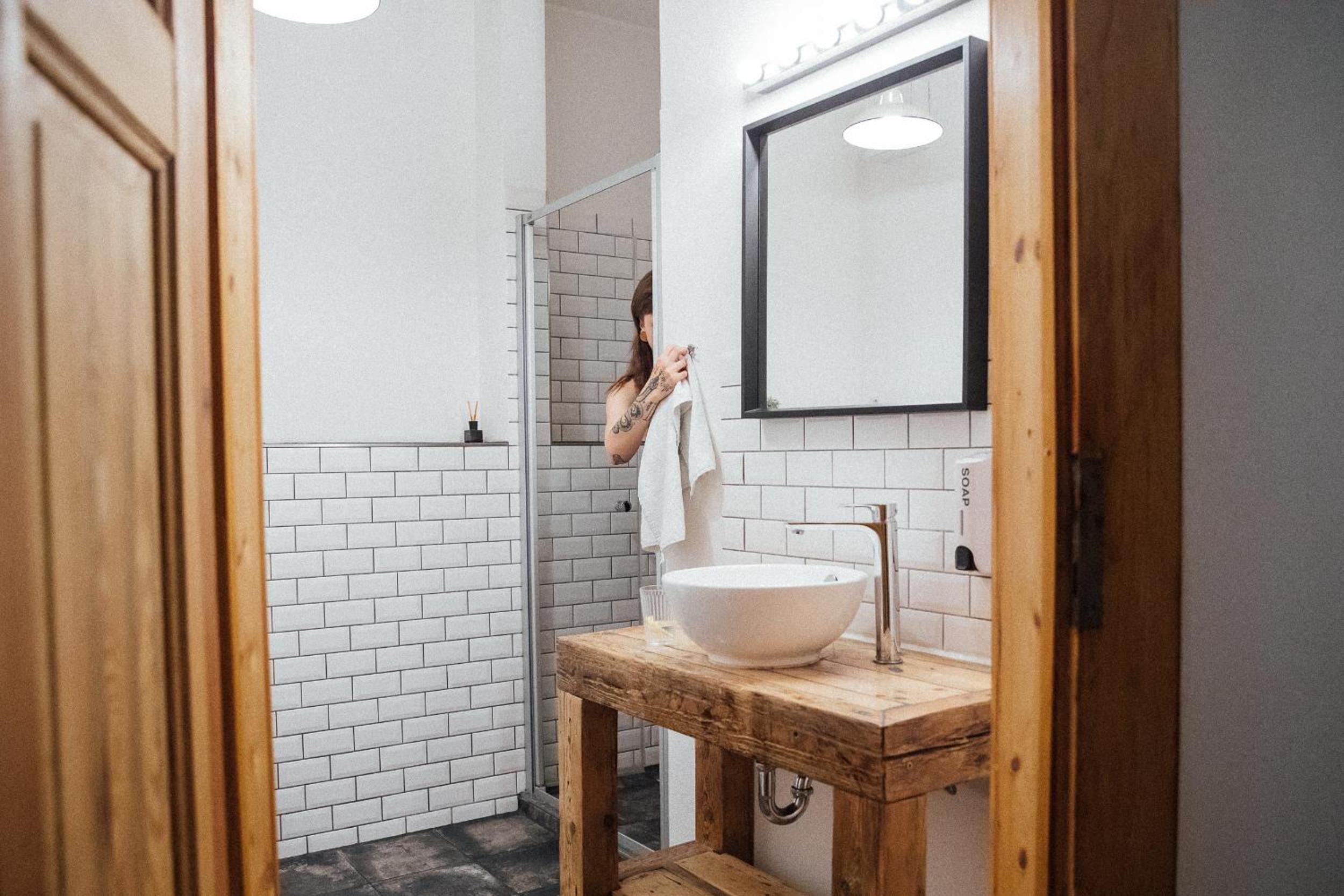 A bathroom with a white sink, a wooden vanity, and a mirror.