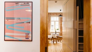 A kitchen with a brick wall, a window, and a table with chairs.