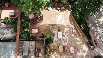 An aerial view of a backyard with a patio area, seating, and a fire pit.