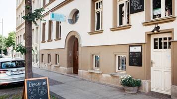 A building with a sign for a hostel and a chalkboard menu.