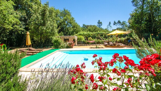 A swimming pool surrounded by lush greenery, with a stone wall and a hammock. - House with private pool. Quiet Location. Fenced/secured pool area (Santa Restituta)