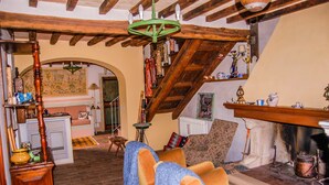 A rustic room with wooden beams, a fireplace, and a collection of decorative items on shelves. - House with private pool. Quiet Location. Fenced/secured pool area (Santa Restituta)