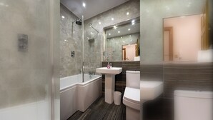 Une salle de bain moderne avec une douche à parois de verre, une baignoire sur pieds, un lavabo sur colonne et des toilettes.