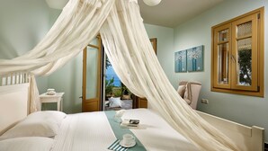 Une chambre à coucher avec un lit à baldaquin, une vue sur l’extérieur et une petite table sur laquelle se trouvent une tasse et un livre.