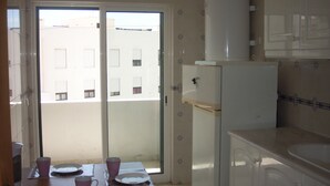 Eine Küche mit Kühlschrank, Spüle und Fenster mit Blick auf Gebäude.