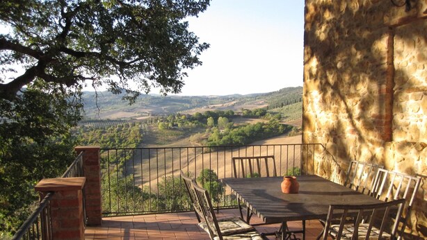 A terrace with a table and chairs, overlooking a scenic landscape. - Villa Mulinello, secluded, panoramic view over Montepulciano valley. (torrita di siena, fraz. montefollonico)