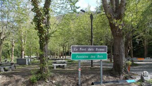 A signpost with bilingual text indicating a location named 'La Font des Bois' and 'Fontaine des Buis'.
