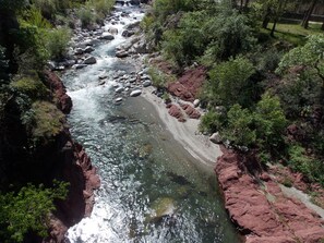 A river flowing through a rocky landscape with dense greenery on both sides.