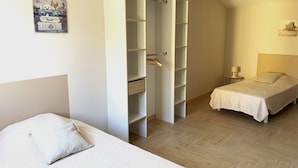 A bedroom with a bed, a wardrobe, and a nightstand.