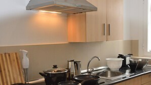 Une cuisine moderne dotée d’appareils électroménagers en acier inoxydable, d’un évier et d’armoires en bois.
