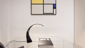 Une vitrine transparente où se trouve un livre intitulé « art » et une lampe noire.