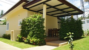 A two-story house with a covered porch, a small garden, and a staircase leading to the entrance. - Blue Wave Samui Bophut (Koh Samui)