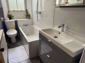 A bathroom with a toilet, bathtub, and sink.