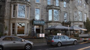 A historic building with a sign reading 'BLACK IVY' indicating a pub with bars, a draughthouse, and a terrace.