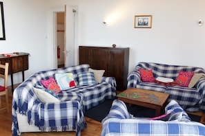 A living room with two sofas, a wooden cabinet, and a small table. - Classic 5BDR Flat Overlooking Bruntsfield Links (Edinburgh)