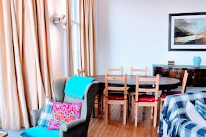 Une pièce chaleureuse avec une table à manger, des chaises, un canapé et un tableau au mur.