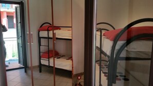 A room with bunk beds, a tiled floor, and a door leading outside.