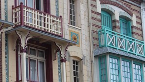 Un bâtiment doté d’un balcon, d’une porte portant l’inscription « RIP » et d’une fenêtre avec des volets.