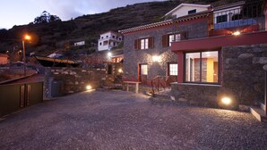 A stone building with a red roof and a balcony. - Casa do Barco, Rustic house with salt pool and sea view (Arco da Calheta)