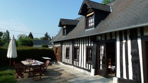 A traditional half-timbered building with a gravel patio, outdoor seating, and a dog. - Game room, fireplace and garden! (Le Faulq)