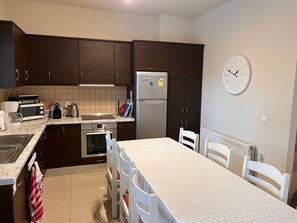 Compact kitchen with a refrigerator, microwave, oven, and sink.